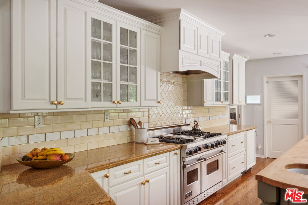 1265 Inverness Drive Pasadena, CA 91103 - Photo 21 of 56 a kitchen with stainless steel appliances a stove a sink and a white cabinets