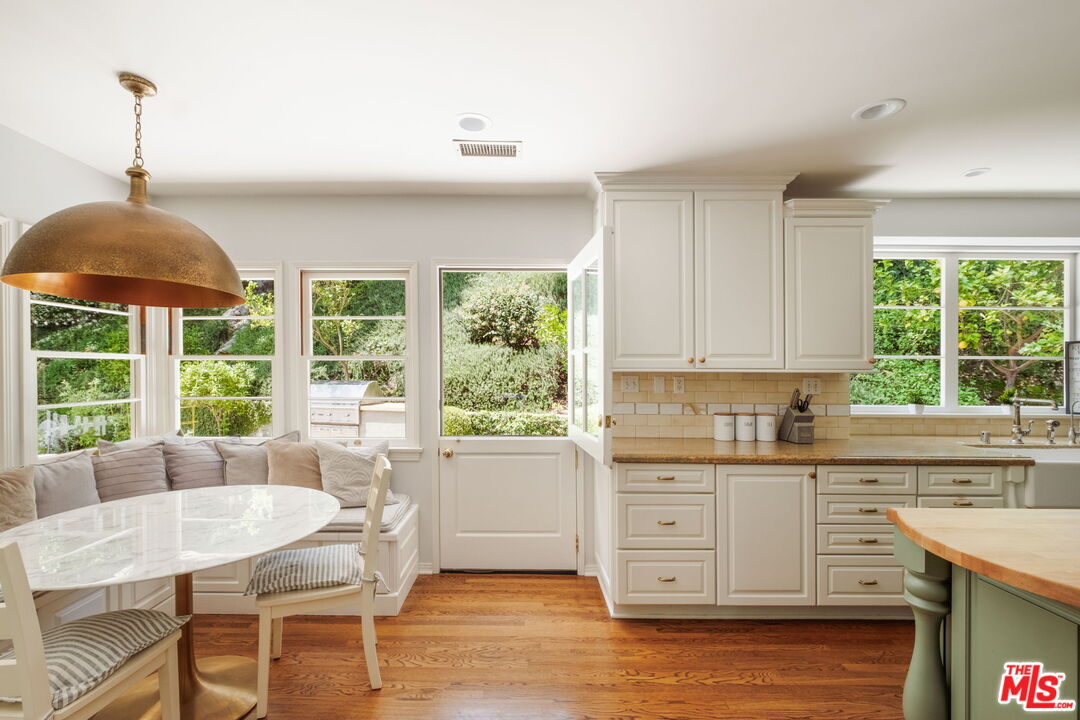 1265 Inverness Drive Pasadena, CA 91103 - Photo 26 of 56 a kitchen with stainless steel appliances granite countertop a stove a sink dishwasher and white cabinets with wooden floor
