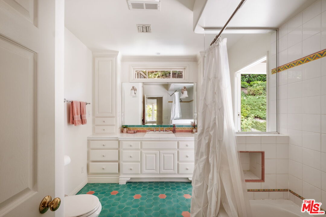 1265 Inverness Drive Pasadena, CA 91103 - Photo 42 of 56 a bathroom with a tub sink vanity mirror and next to a window