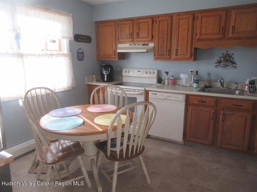 22 River Glen Road Wallkill, NY 12589 - Photo 2 of 8 a kitchen with a dining table chairs and cabinets
