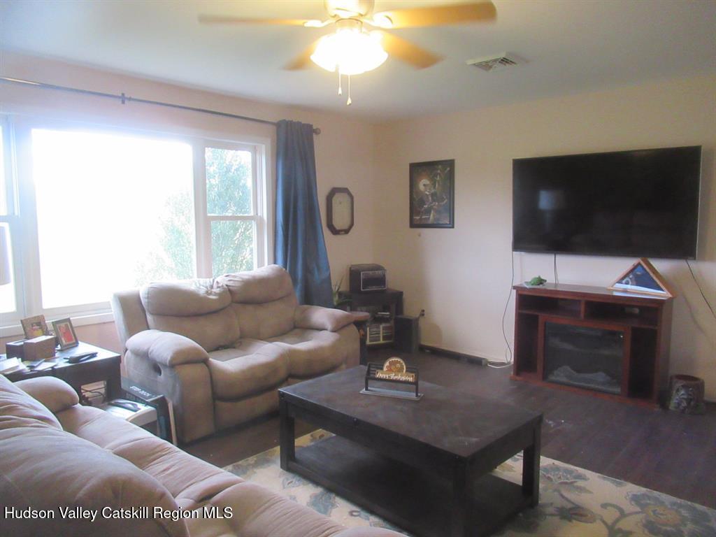 22 River Glen Road Wallkill, NY 12589 - Photo 5 of 8 a living room with furniture a flat screen tv and a large window
