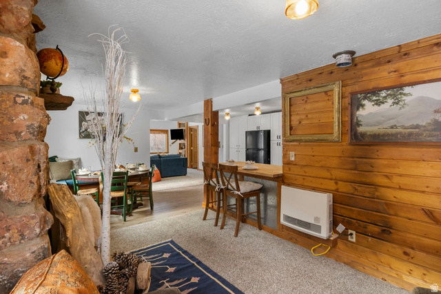 2189 Samak Park Loop, Unit 43 Kamas, UT 84036 - Photo 15 of 48 Living area featuring heating unit, wood walls, and a textured ceiling