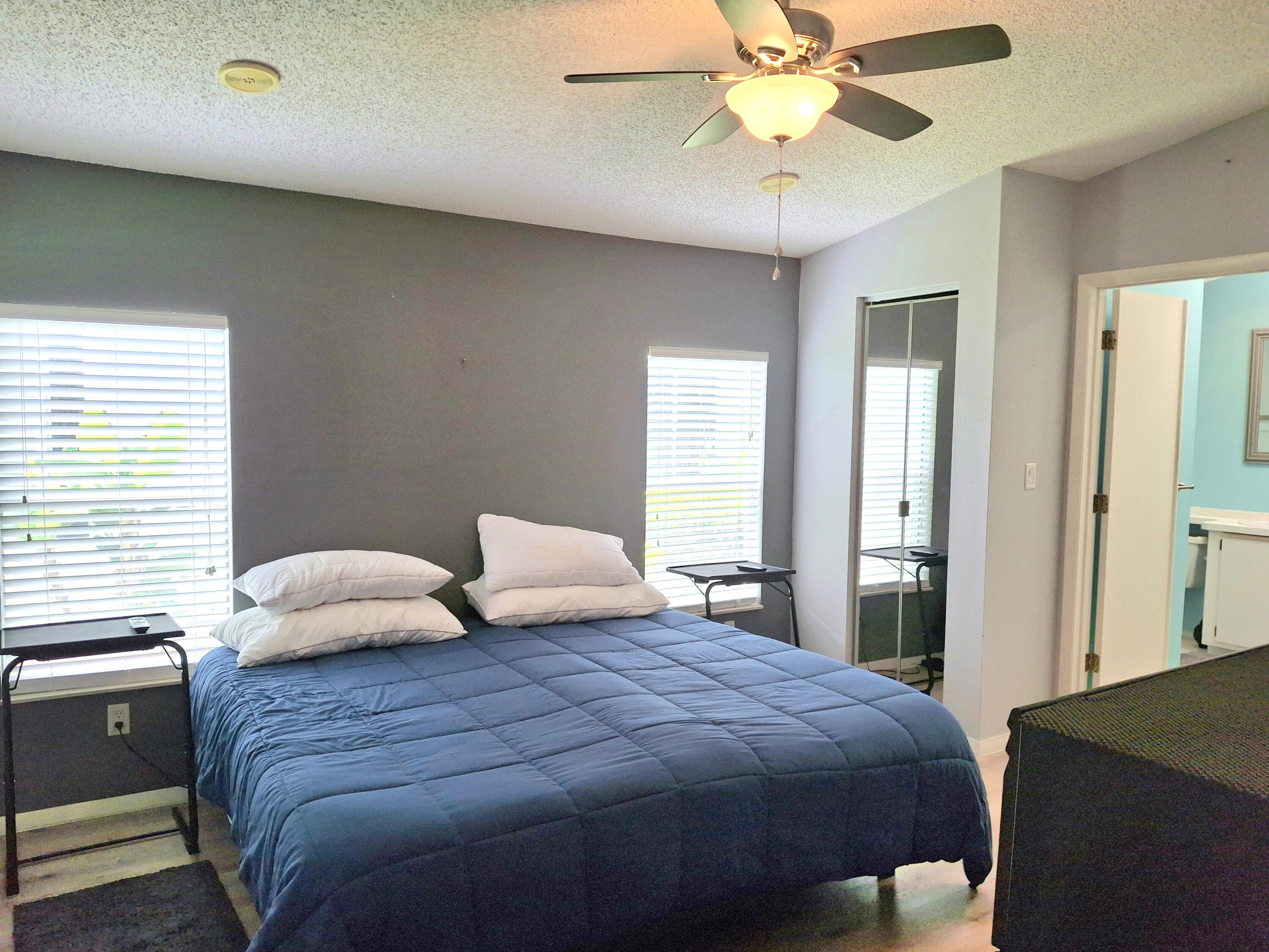 8483 Schefflera Court Port St. Lucie, FL 34952 - Photo 14 of 33 a bedroom with a bed and a chandelier