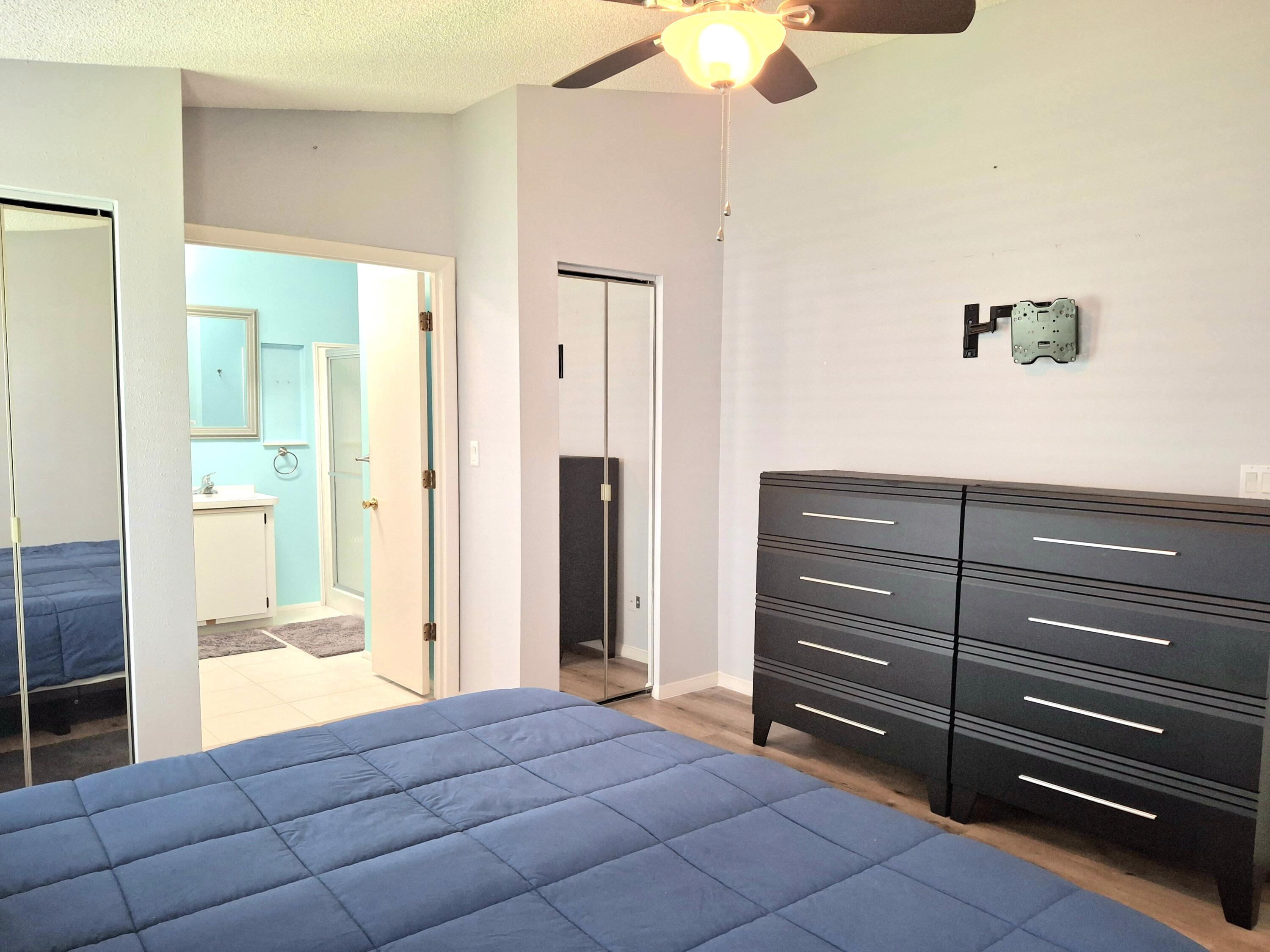 8483 Schefflera Court Port St. Lucie, FL 34952 - Photo 15 of 33 a bedroom with a bed and a chandelier