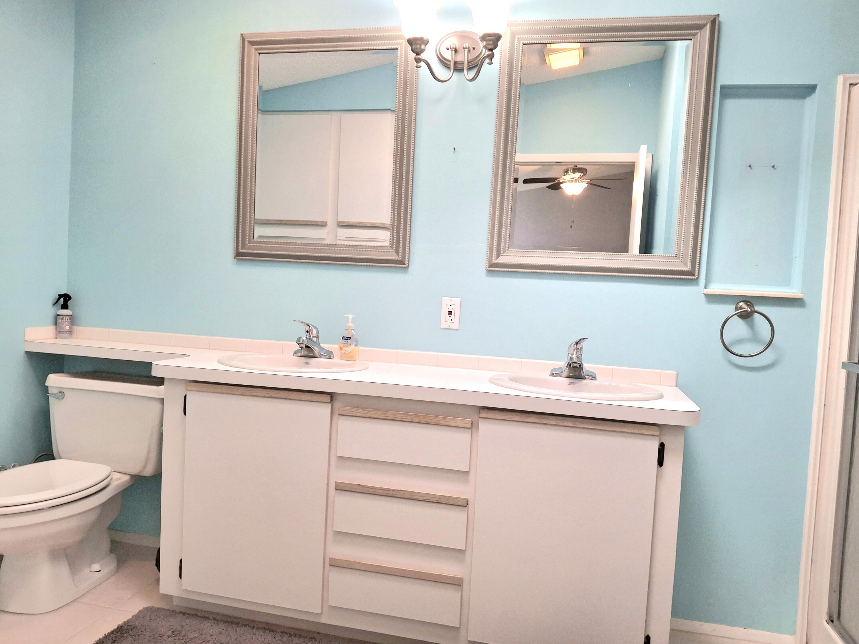 8483 Schefflera Court Port St. Lucie, FL 34952 - Photo 19 of 33 a bathroom with a toilet sink and mirror