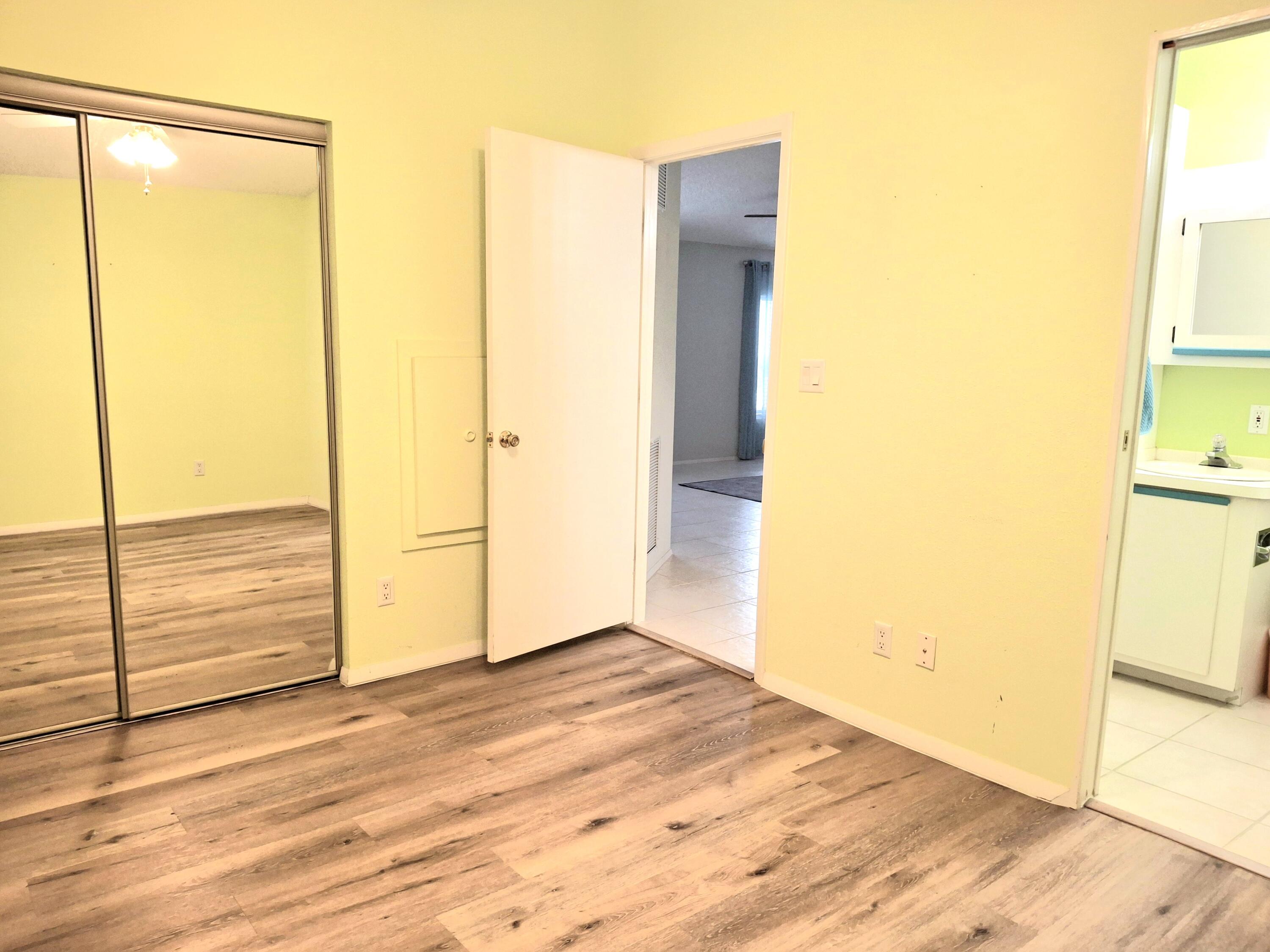 8483 Schefflera Court Port St. Lucie, FL 34952 - Photo 23 of 33 an empty room with wooden floor and door