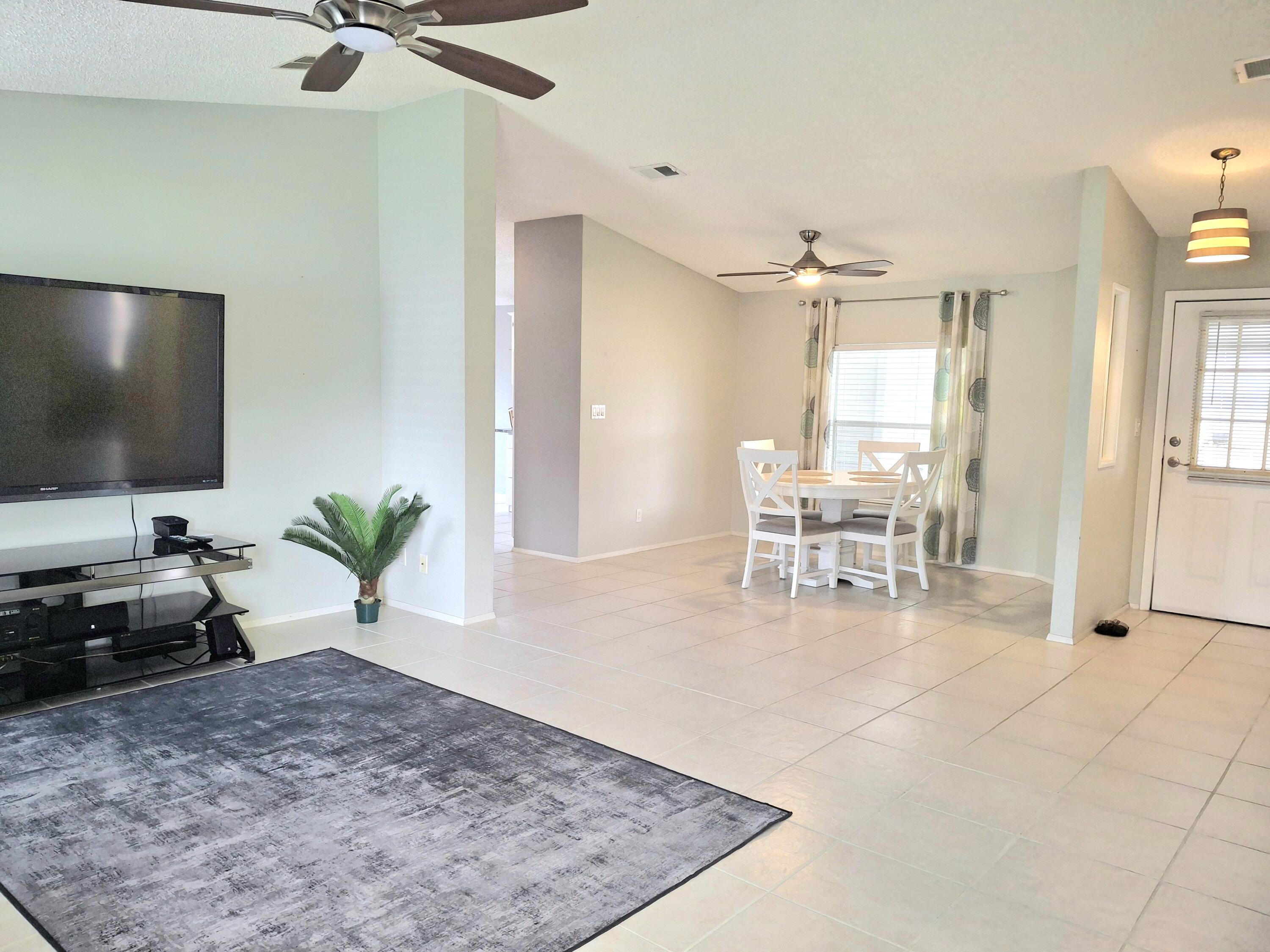 8483 Schefflera Court Port St. Lucie, FL 34952 - Photo 4 of 33 a living room with furniture and a flat screen tv