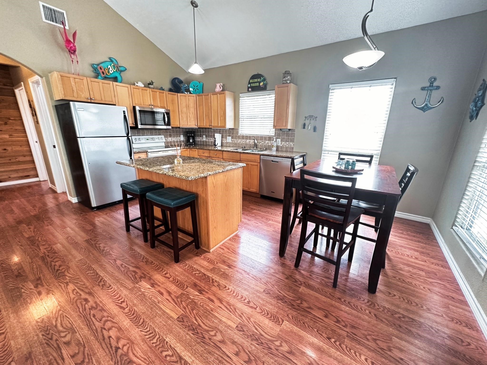 1867 County Road 291 Sargent, TX 77414 - Photo 14 of 31 a kitchen with stainless steel appliances a dining table chairs stove refrigerator and cabinets