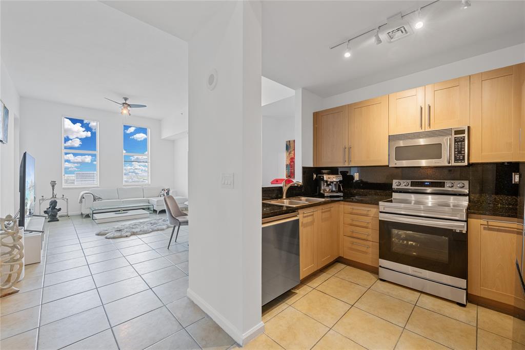 511 Southeast 5th Avenue, Unit 1906 Fort Lauderdale, FL 33301 - Photo 6 of 64 a kitchen with stainless steel appliances a sink a stove top oven a counter space and cabinets