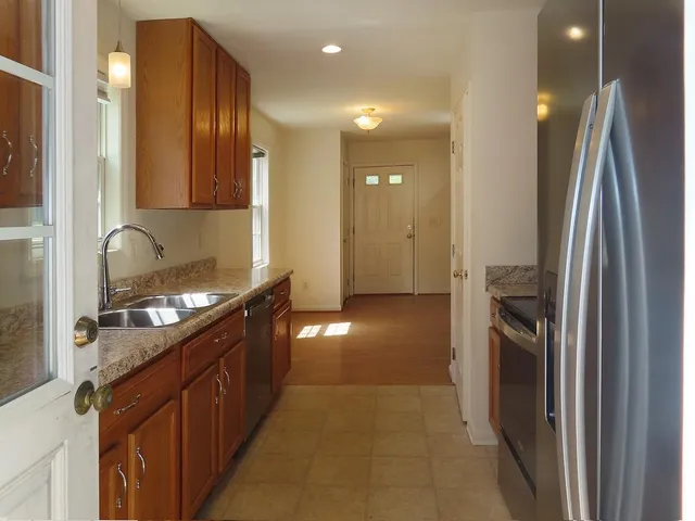 a kitchen with stainless steel appliances granite countertop a refrigerator and a sink