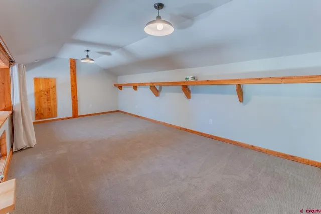 a bedroom with a bed couch and windows