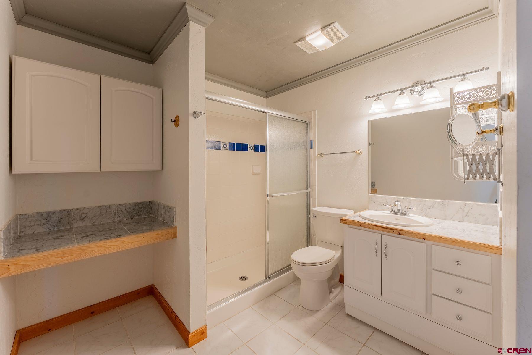 169 Camino Del Rio, Unit 8 Gunnison, CO 81230 - Photo 17 of 35 a bathroom with a granite countertop sink a toilet and bathtub