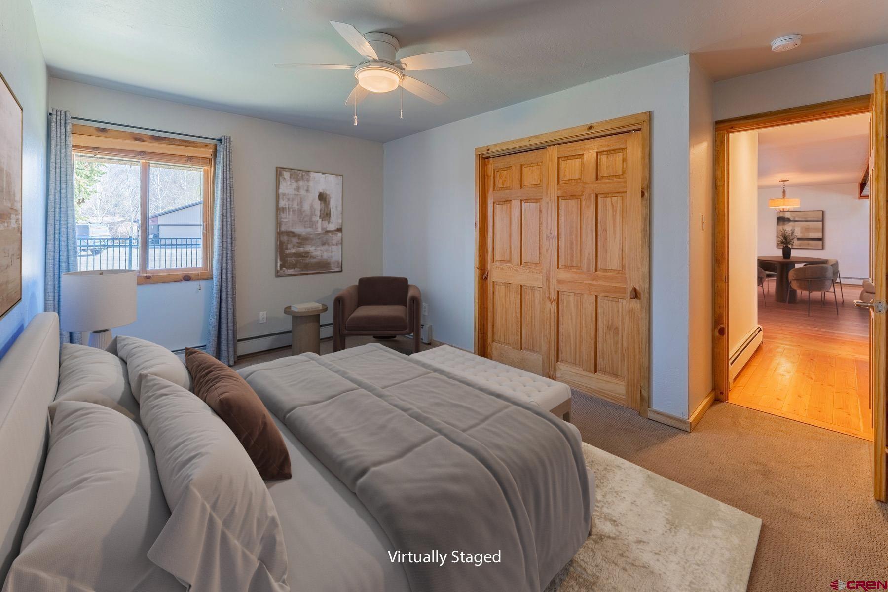 169 Camino Del Rio, Unit 8 Gunnison, CO 81230 - Photo 18 of 35 a bedroom with a bed and a chandelier