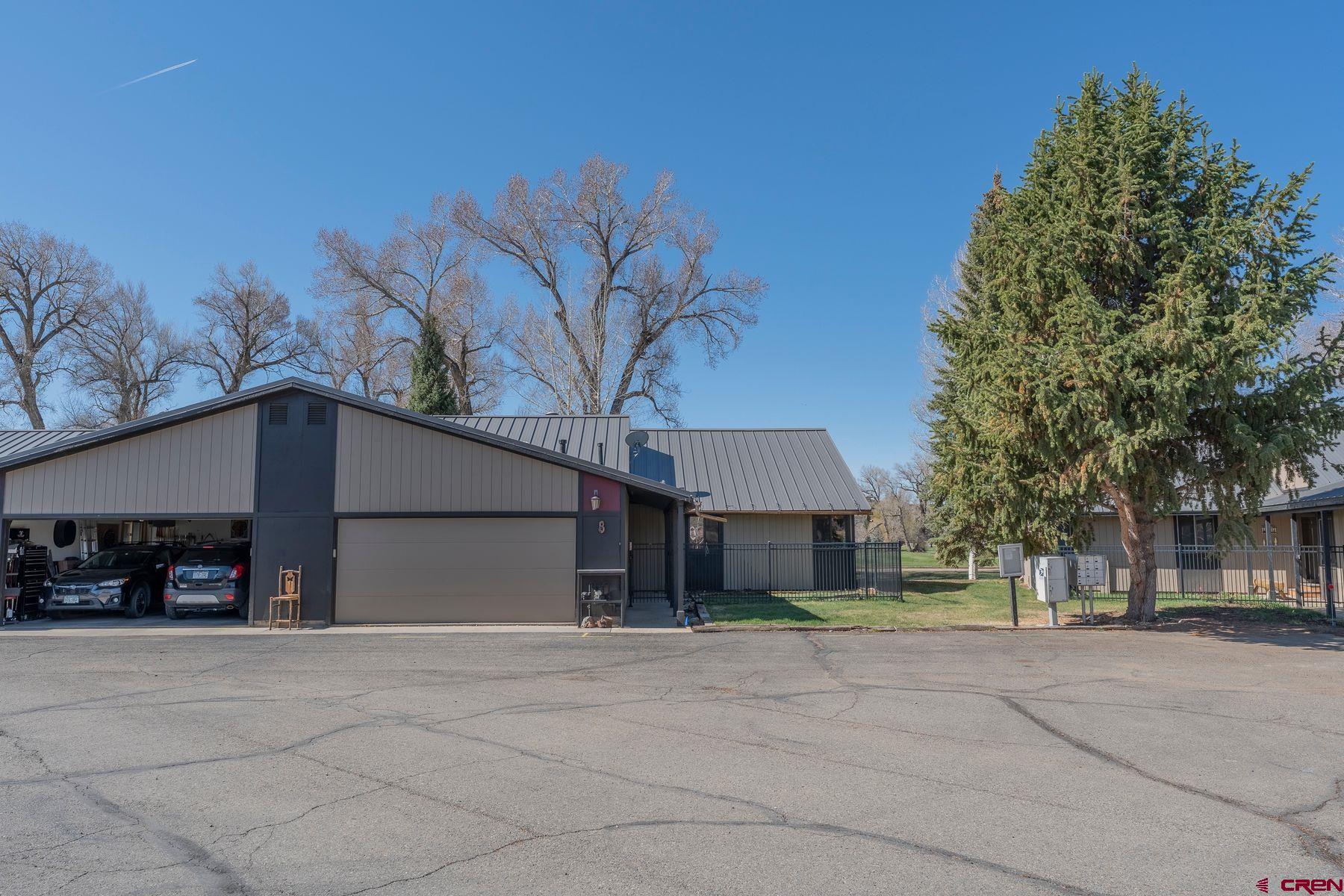 169 Camino Del Rio, Unit 8 Gunnison, CO 81230 - Photo 28 of 35 a view of a house with a yard and a garage
