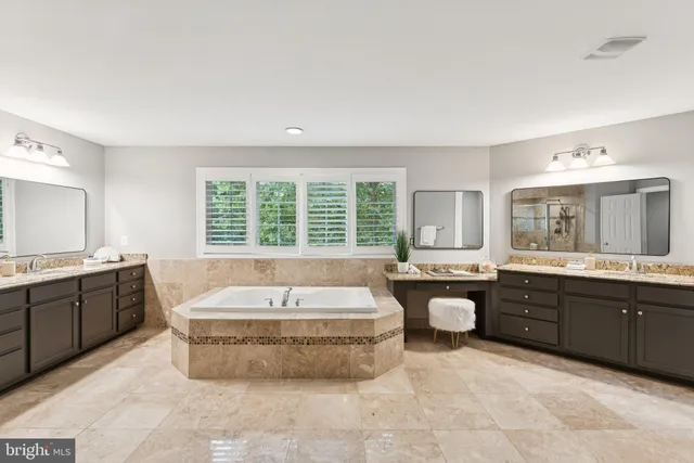 a bathroom with a tub a sink a mirror and a shower