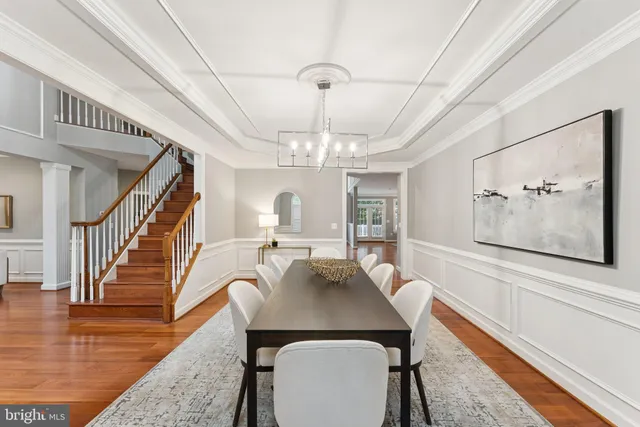 a view of a dining room with furniture a chandelier and wooden floor