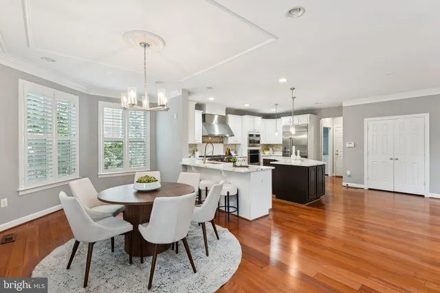 a view of a dining room and livingroom with furniture wooden floor a chandelier
