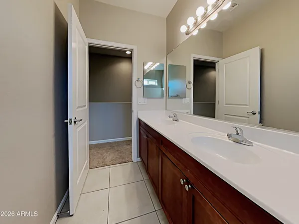 a spacious bathroom with a double vanity sink a mirror and a shower