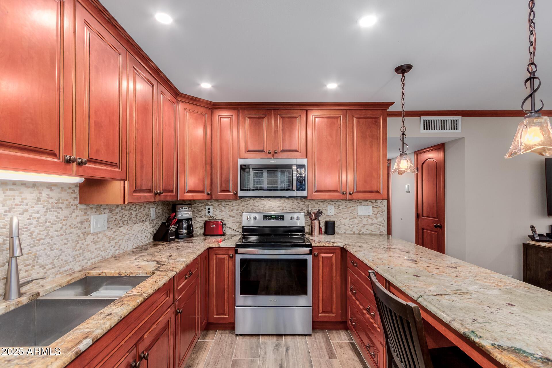5525 East Thomas Road, Unit E3 Phoenix, AZ 85018 - Photo 12 of 31 a kitchen with a stove a sink and a refrigerator