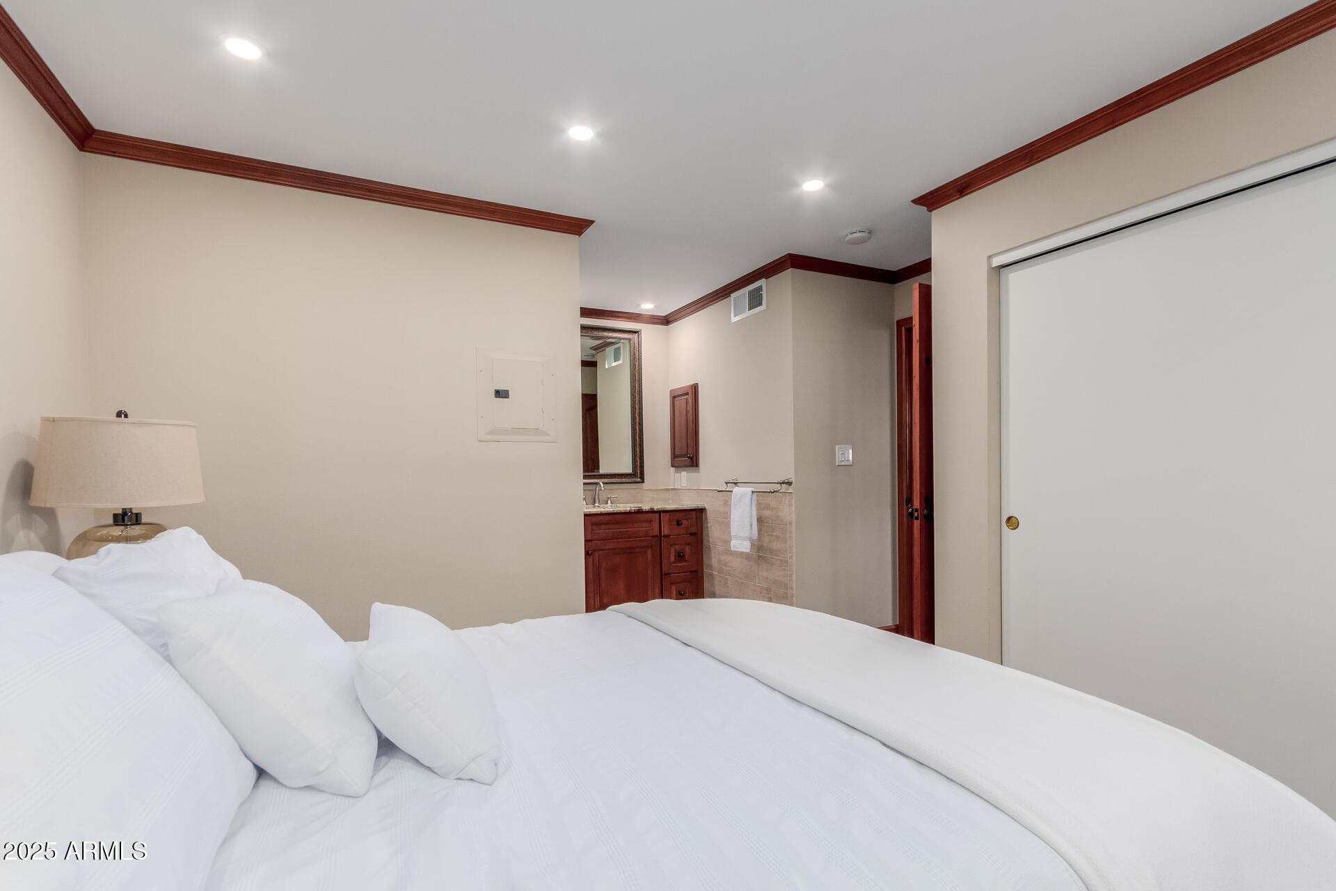 5525 East Thomas Road, Unit E3 Phoenix, AZ 85018 - Photo 16 of 31 a bedroom with a large bed and a chandelier
