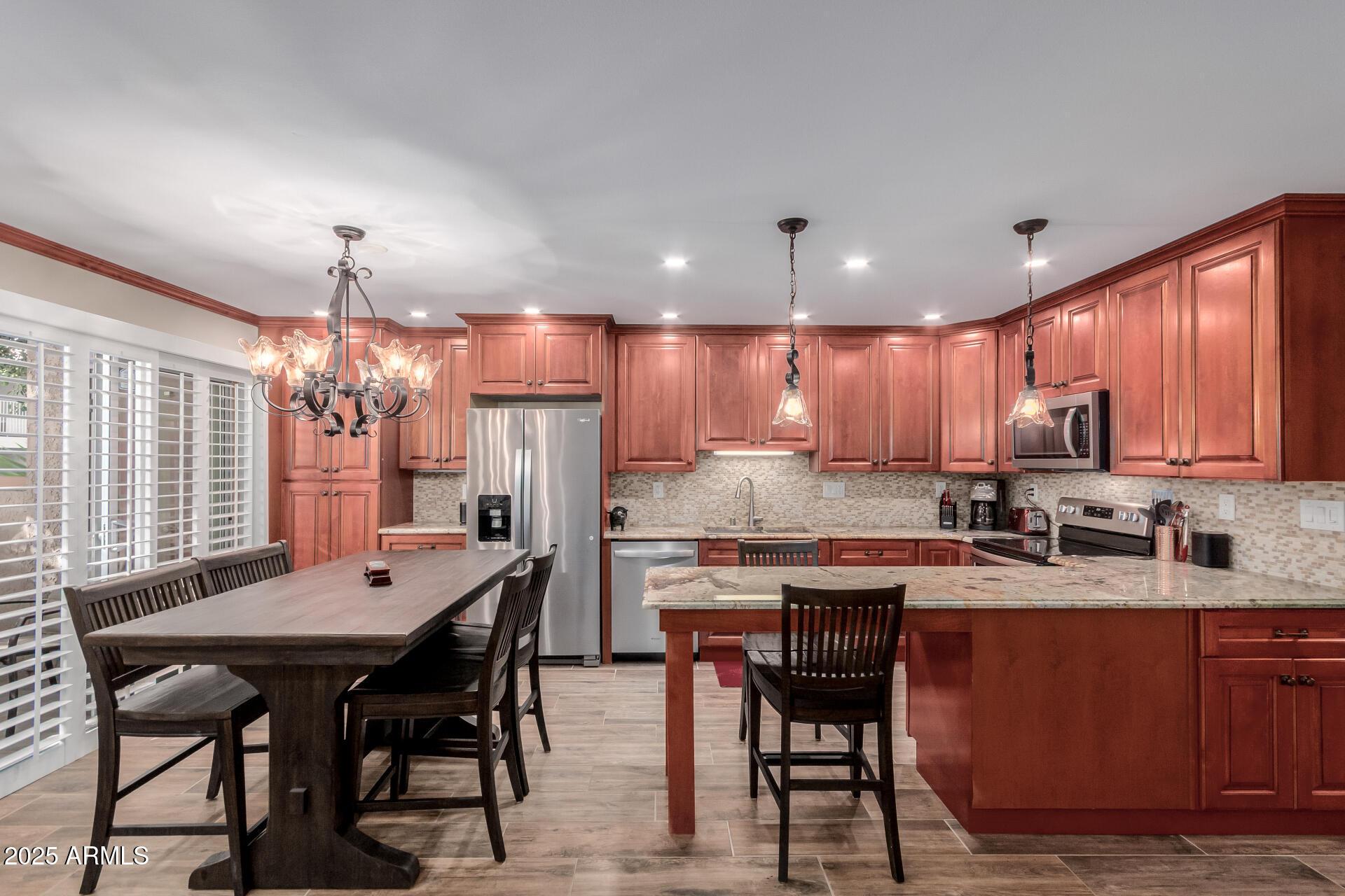5525 East Thomas Road, Unit E3 Phoenix, AZ 85018 - Photo 9 of 31 a kitchen with a dining table chairs and refrigerator