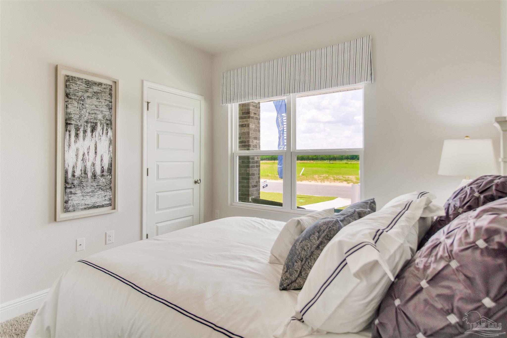 4745 Redhead Court Pace, FL 32571 - Photo 7 of 44 a bed sitting in a bedroom next to a window