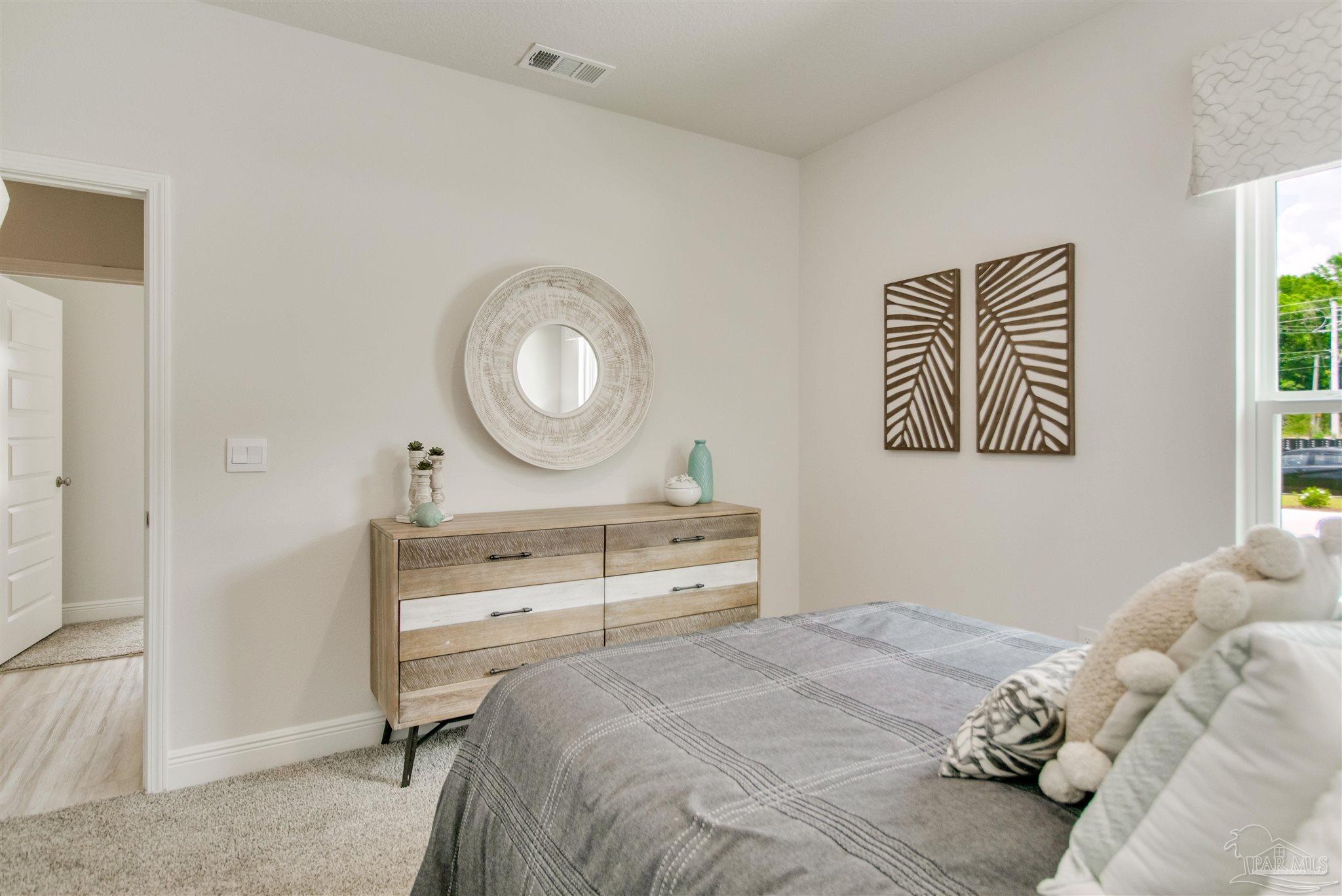 4745 Redhead Court Pace, FL 32571 - Photo 10 of 44 a bedroom with a bed and a chandelier