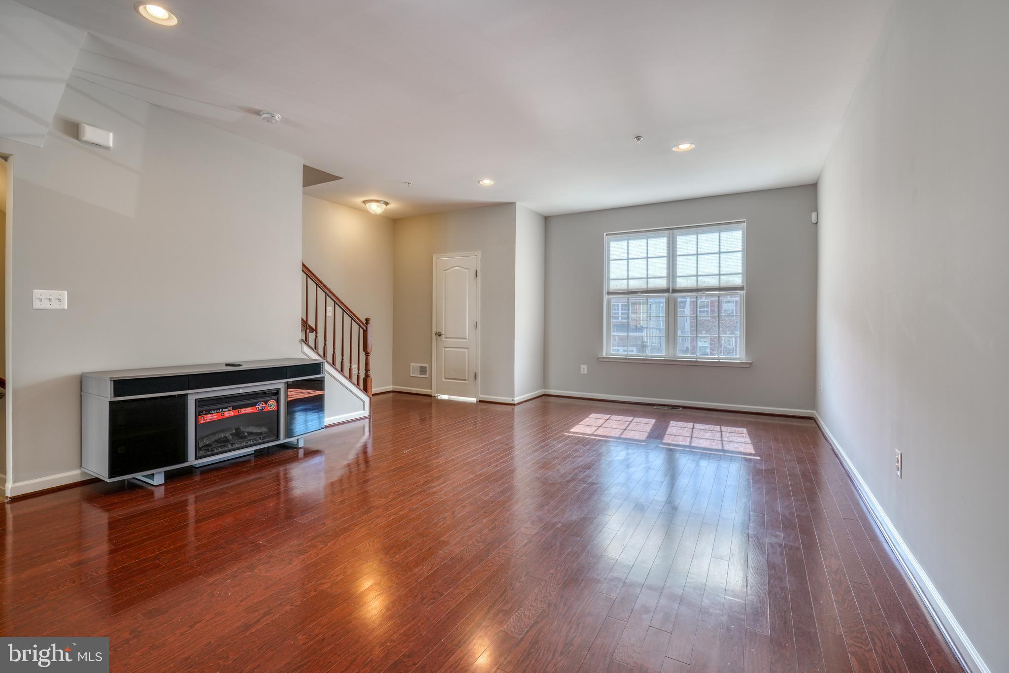 985 Morgan Run Road Middle River, MD 21220 - Photo 7 of 33 an empty room with wooden floor fireplace and windows