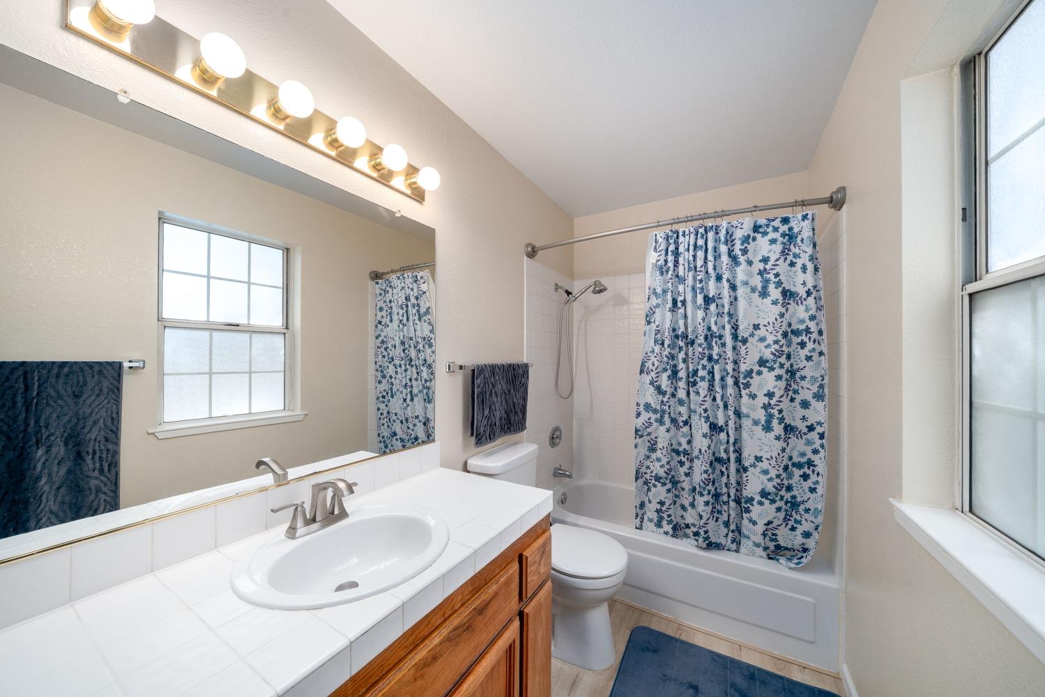 4112 Alex Lane Carmichael, CA 95608 - Photo 28 of 36 a bathroom with a sink a toilet a shower and a large mirror