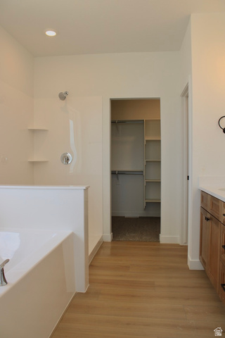 2613 Scarlet Road, Unit 258 Eagle Mountain, UT 84005 - Photo 15 of 32 Spacious bathroom featuring a built-in tub, separate shower with chrome fixtures, wood-finish flooring, recessed lighting, and a walk-in closet with built-in shelving