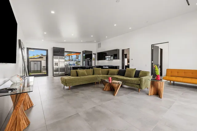 a living room with stainless steel appliances kitchen island granite countertop furniture and fireplace