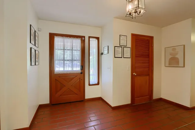 a living room with furniture and a mirror next to a window