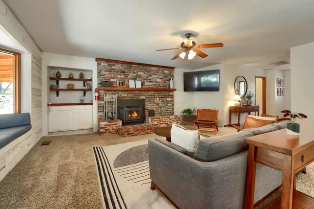 a living room with fireplace furniture and a large window