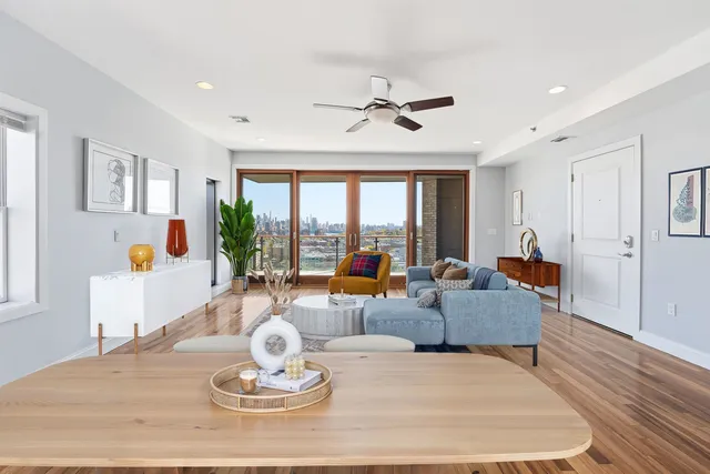 a living room with furniture kitchen view and a large window