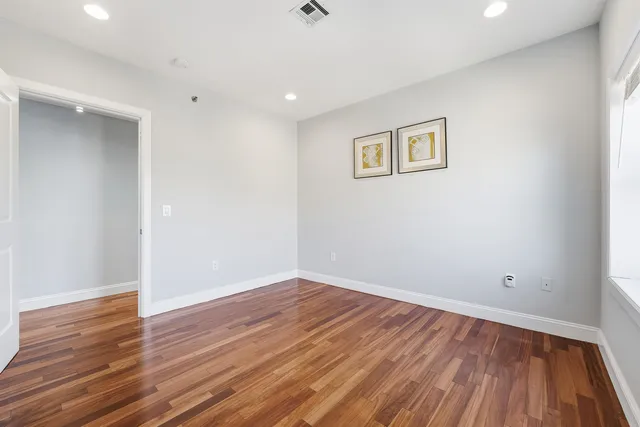 a view of a room with wooden floor and white walls