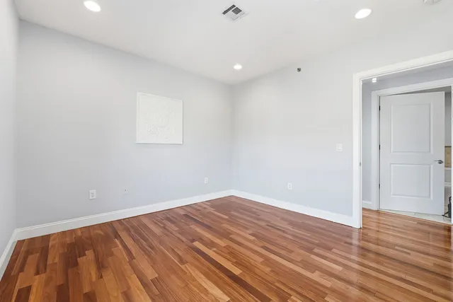 a view of room with wooden floor and white walls