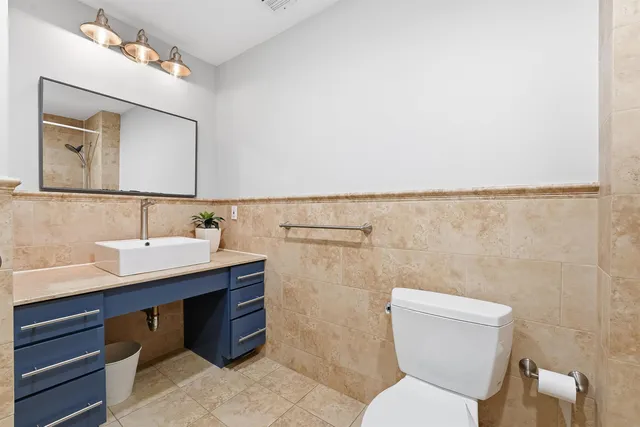 a bathroom with a toilet sink and mirror