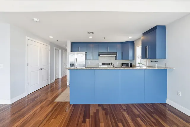 a kitchen with wooden floors and wooden cabinets