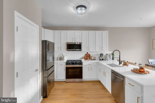 a kitchen with stainless steel appliances granite countertop a refrigerator sink and white stove