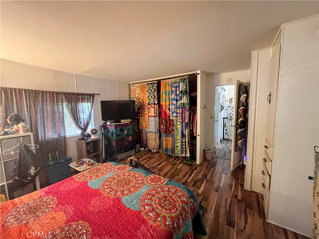 4041 Pedley Road, Unit 93 Riverside, CA 92509 - Photo 15 of 27 a bed room with a bed a television and dresser