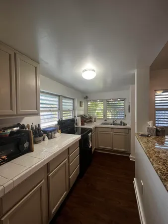a kitchen with a sink a stove and cabinets