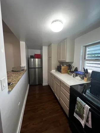 a kitchen with refrigerator cabinets and wooden floor