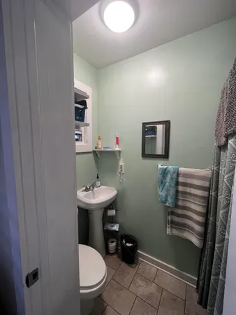 a bathroom with a sink toilet and a mirror