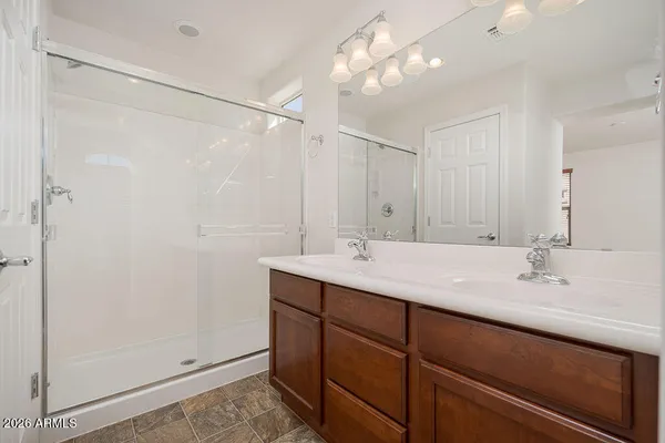 a bathroom with a double vanity sink mirror and shower