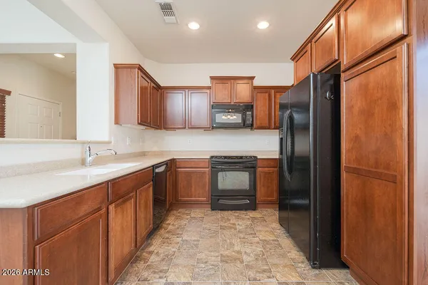 a kitchen with stainless steel appliances granite countertop a refrigerator and a sink