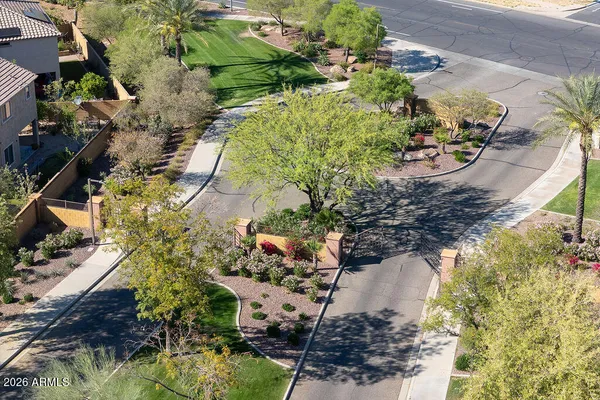 an aerial view of residential houses with outdoor space and trees