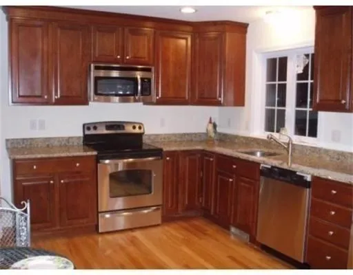 a kitchen with granite countertop a stove and a microwave