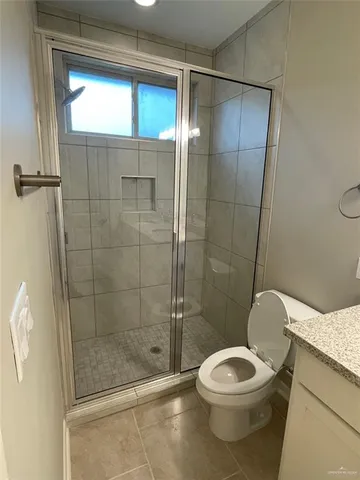 a white toilet sitting next to a shower
