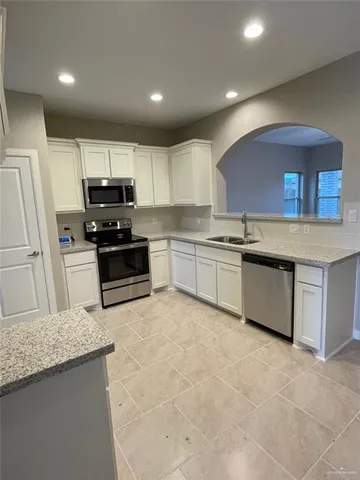 a kitchen with stainless steel appliances granite countertop a stove sink and cabinets