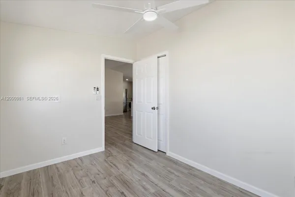 a view of an empty room with wooden floor